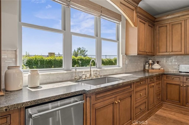 3 Stockmen Rd, Ladera Ranch, CA 92694 - kitchen featuring stainless steel dishwasher, brown cabinetry, backsplash, and plenty of natural light
