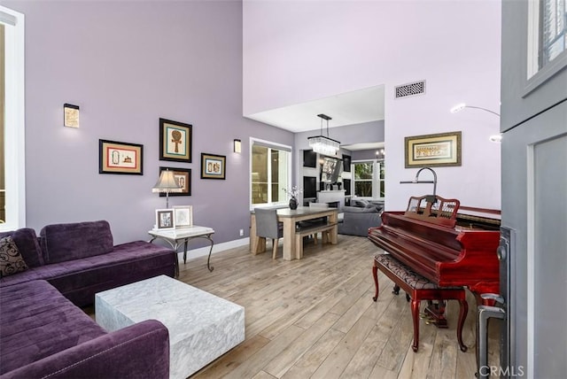 15 Surfbird Ln, Aliso Viejo, CA 92656 - living room featuring a high ceiling, light wood finished floors, and a chandelier