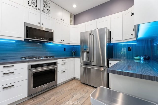 15 Surfbird Ln, Aliso Viejo, CA 92656 - kitchen featuring stainless steel appliances, light wood finished floors, backsplash, white cabinets, and recessed lighting