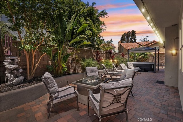 15 Surfbird Ln, Aliso Viejo, CA 92656 - patio terrace at dusk with a hot tub, a patio area, a fenced backyard, and an outdoor living space with a fire pit
