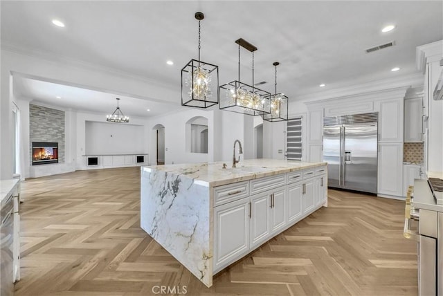 12149 Jonathan Dr, Riverside, CA 92503 - kitchen with stainless steel built in refrigerator, a chandelier, white cabinets, a fireplace, and ornamental molding