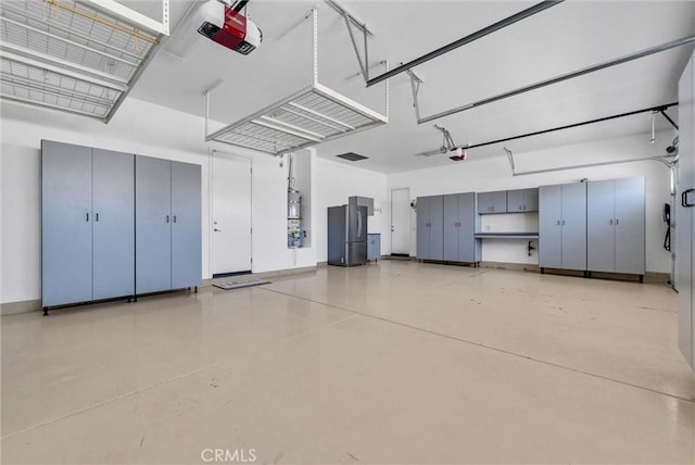 12149 Jonathan Dr, Riverside, CA 92503 - garage featuring a garage door opener and freestanding refrigerator