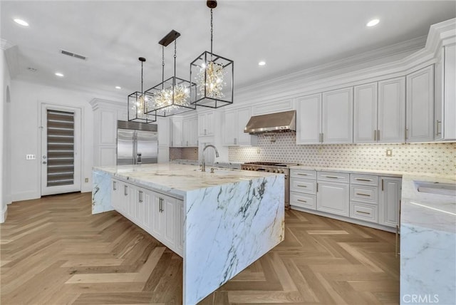 12149 Jonathan Dr, Riverside, CA 92503 - kitchen featuring high end appliances, exhaust hood, a chandelier, white cabinets, and a large island