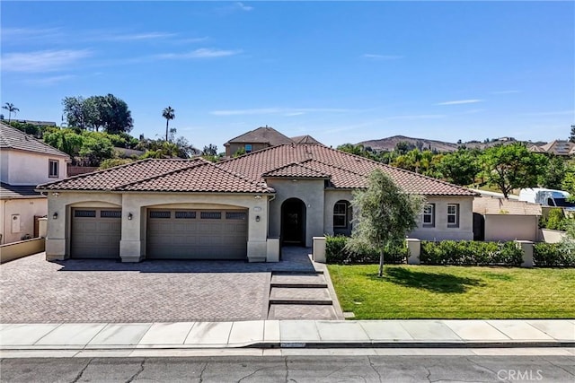 12149 Jonathan Dr, Riverside, CA 92503 - mediterranean / spanish-style home with stucco siding, a tile roof, an attached garage, and a front lawn