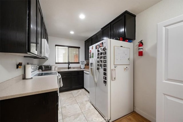 1812 Riverside Ave, Paso Robles, CA 93446 - kitchen with white appliances, dark cabinetry, light countertops, and recessed lighting