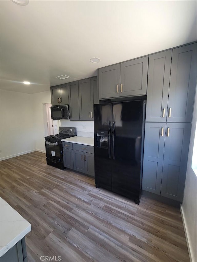 8339 Manzanar Ave, Pico Rivera, CA 90660 - kitchen featuring black appliances, gray cabinetry, wood finished floors, light countertops, and recessed lighting