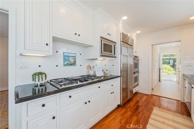 426 Via La Selva, Redondo Beach, CA 90277 - kitchen with built in appliances, dark countertops, white cabinetry, ornamental molding, and decorative backsplash