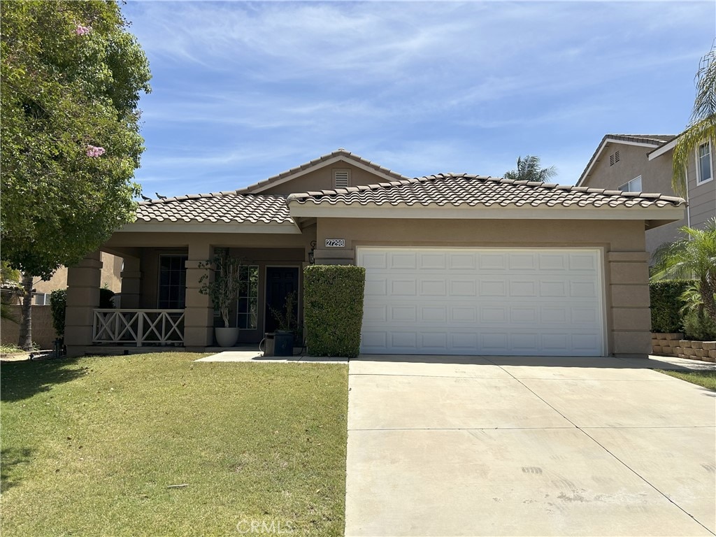 27298 Buffalo Trl, Corona, CA 92883 - view of front of home with driveway, a front yard, a garage, stucco siding, and a tile roof