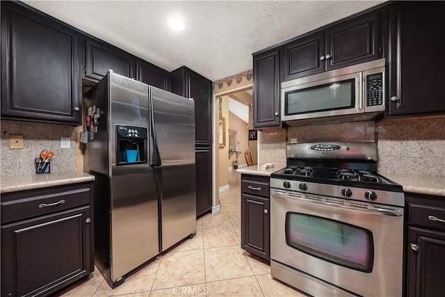 37028 Velutina Way, Palmdale, CA 93550 - kitchen featuring appliances with stainless steel finishes, tasteful backsplash, light countertops, dark cabinets, and a textured ceiling