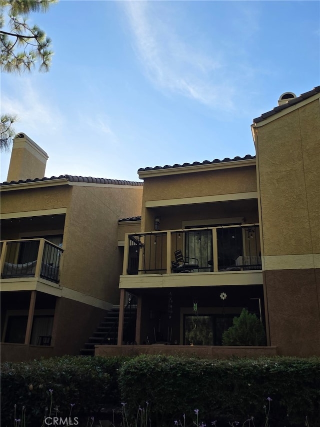 10655 Lemon Ave Unit 1508, Rancho Cucamonga, CA 91737 - rear view of property with a balcony, a chimney, stucco siding, and stairs