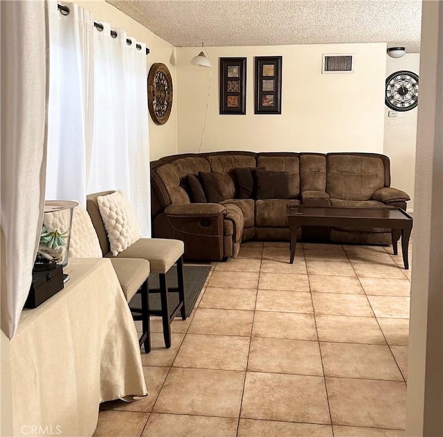 9620 San Vincente Ave, South Gate, CA 90280 - living room featuring a textured ceiling and light tile patterned floors