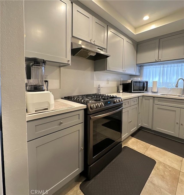 9620 San Vincente Ave, South Gate, CA 90280 - kitchen with stainless steel range with gas stovetop, under cabinet range hood, gray cabinetry, light countertops, and recessed lighting
