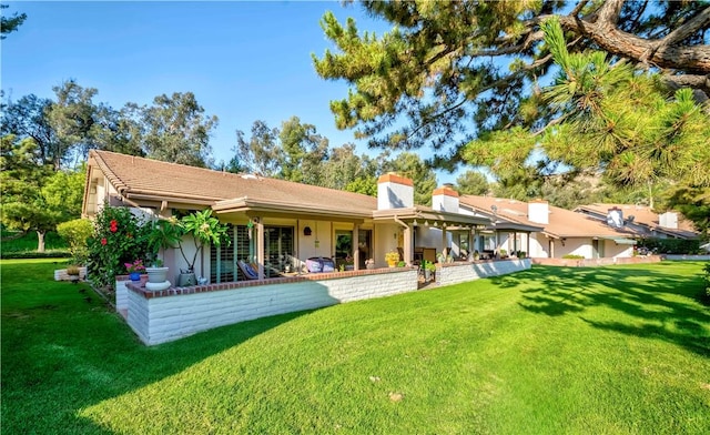 662 Via Zapata, Riverside, CA 92507 - back of house with a lawn, a chimney, and stucco siding
