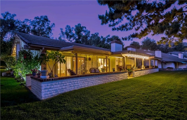 662 Via Zapata, Riverside, CA 92507 - back of property at dusk featuring a yard and a chimney