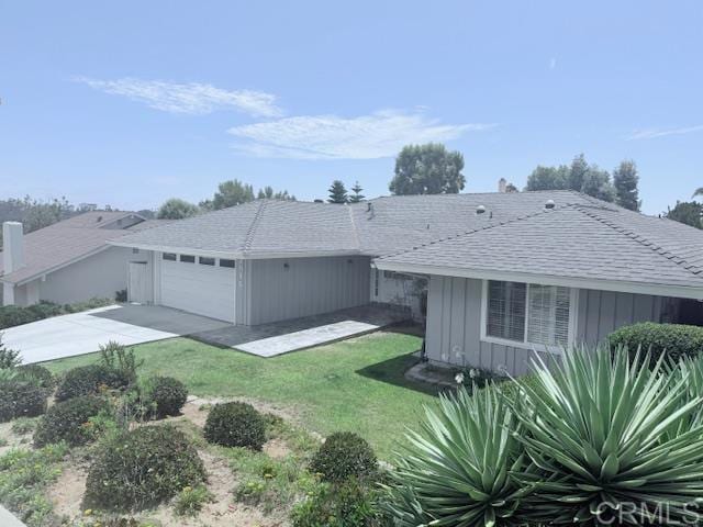 2015 Elevada St, Oceanside, CA 92054 - view of front of house featuring an attached garage, concrete driveway, a front lawn, board and batten siding, and roof with shingles