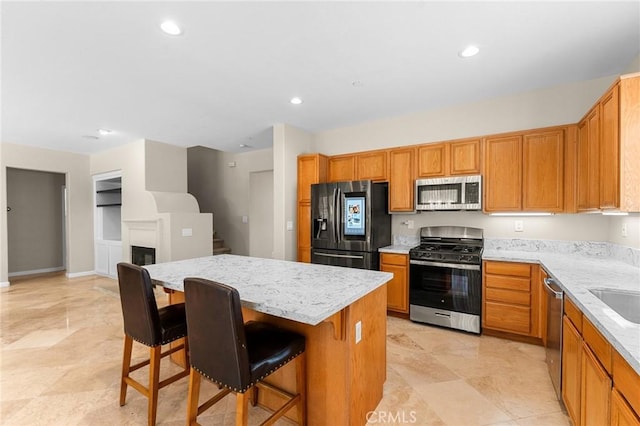 1581 Margit St, Redlands, CA 92374 - kitchen featuring appliances with stainless steel finishes, a center island, brown cabinets, and recessed lighting