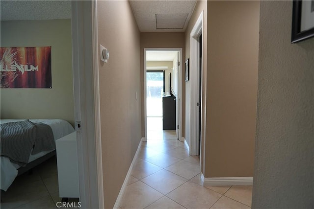 4214 Harrison St, Riverside, CA 92503 - hallway with light tile patterned floors, a textured wall, a textured ceiling, and attic access