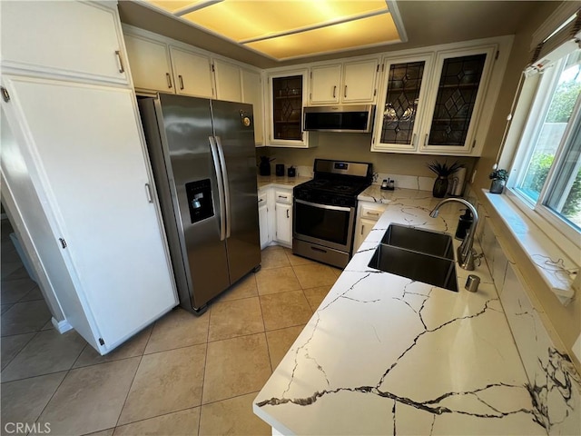 4214 Harrison St, Riverside, CA 92503 - kitchen with stainless steel appliances, light stone counters, glass insert cabinets, and light tile patterned flooring