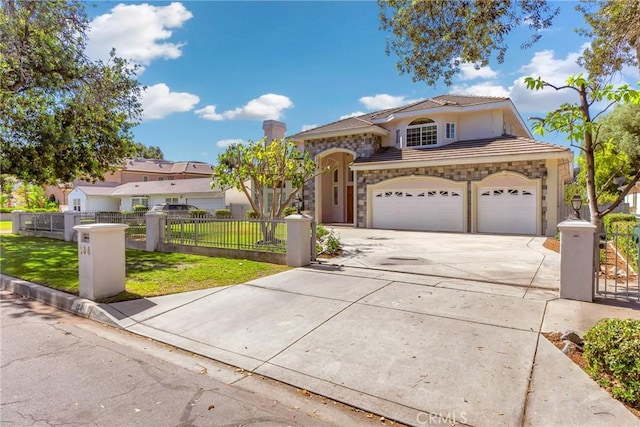 134 E Las Flores Ave, Arcadia, CA 91006 - mediterranean / spanish-style house featuring concrete driveway, stone siding, an attached garage, a fenced front yard, and a tiled roof