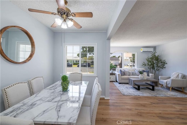 12108 Dunrobin Ave, Downey, CA 90242 - dining room featuring a textured ceiling, wood finished floors, a wall mounted air conditioner, and ceiling fan
