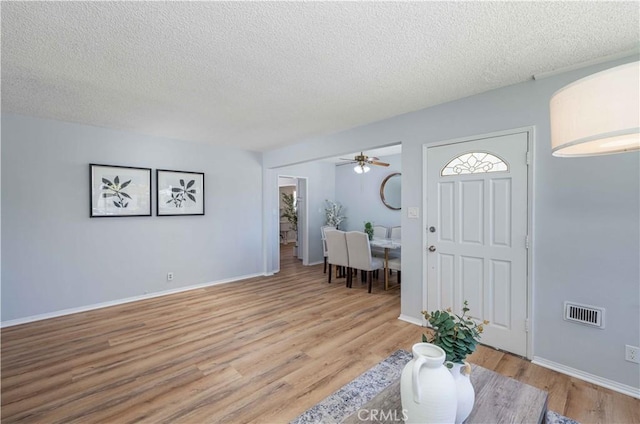 12108 Dunrobin Ave, Downey, CA 90242 - foyer entrance featuring a textured ceiling, light wood-style floors, and a ceiling fan