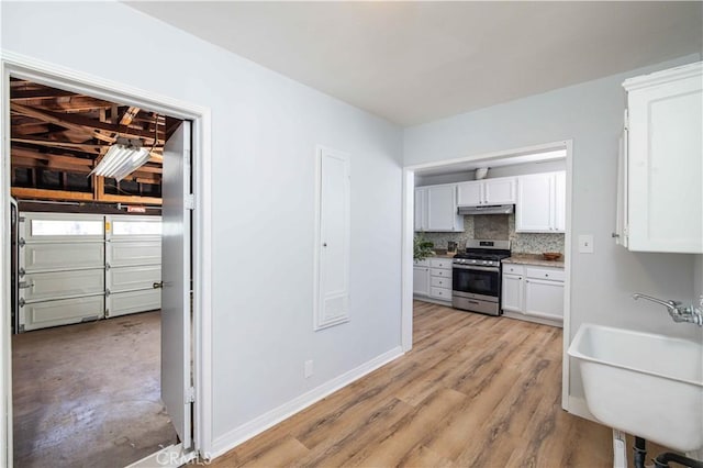 12108 Dunrobin Ave, Downey, CA 90242 - kitchen featuring gas stove, under cabinet range hood, white cabinets, tasteful backsplash, and light countertops