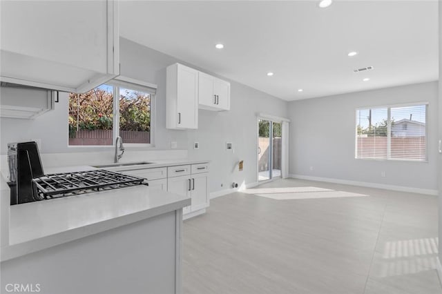 12108 Dunrobin Ave, Downey, CA 90242 - kitchen featuring light countertops, recessed lighting, white cabinetry, range, and open floor plan