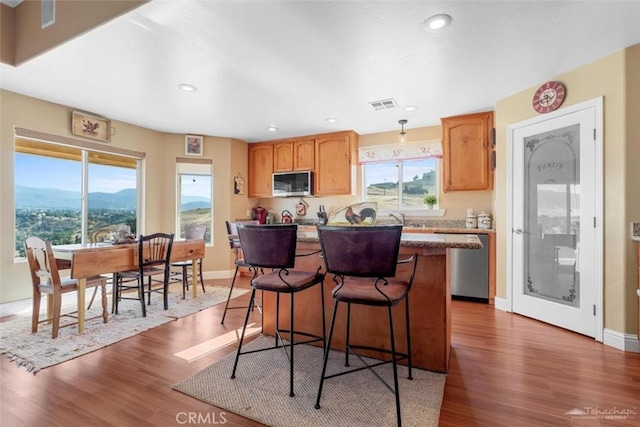 23309 Tak Ct, Tehachapi, CA 93561 - kitchen with stainless steel appliances, a center island, wood finished floors, a breakfast bar, and recessed lighting