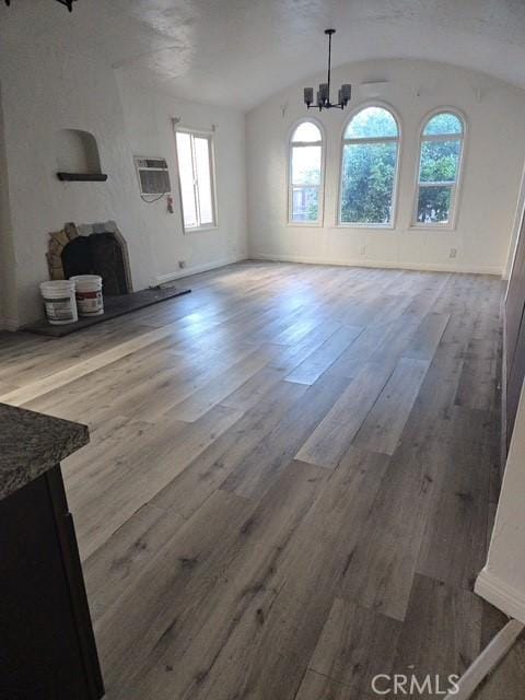 2467 California St, Huntington Park, CA 90255 - unfurnished dining area featuring vaulted ceiling, a wall mounted AC, a chandelier, and wood finished floors