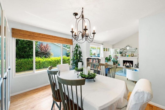 3432 Mount Ariane Dr, San Diego, CA 92111 - dining area with a chandelier, light wood finished floors, lofted ceiling, and a brick fireplace