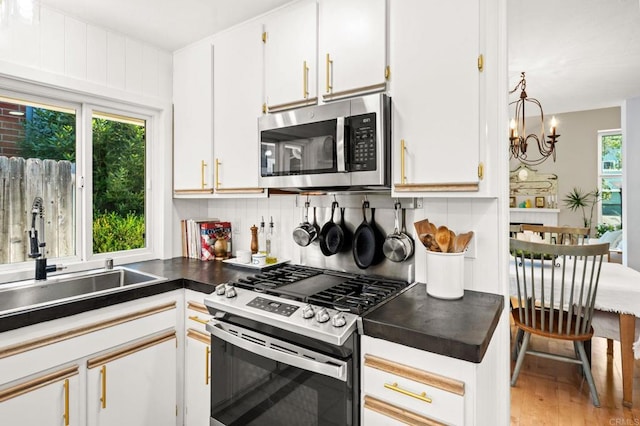 3432 Mount Ariane Dr, San Diego, CA 92111 - kitchen featuring appliances with stainless steel finishes, backsplash, white cabinets, and dark countertops