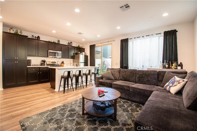 29392 Tourmaline Way, Winchester, CA 92596 - living room featuring light wood-style floors, recessed lighting, and bar with sink