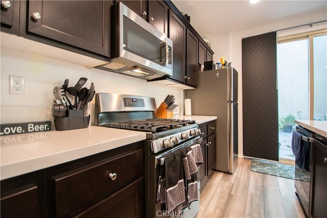 29392 Tourmaline Way, Winchester, CA 92596 - kitchen featuring appliances with stainless steel finishes, light wood-style flooring, dark brown cabinets, and light countertops