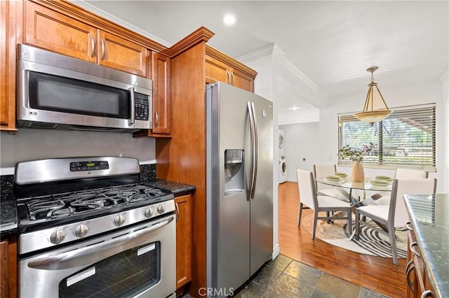 22824 Hilton Head Dr Unit 87, Diamond Bar, CA 91765 - kitchen featuring appliances with stainless steel finishes, brown cabinetry, crown molding, pendant lighting, and washer / dryer