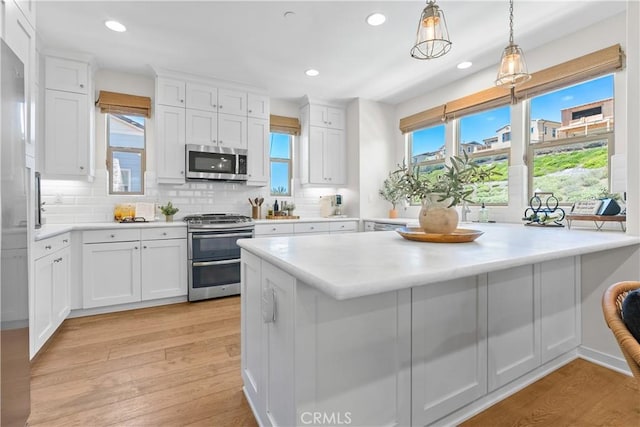 38 Marisol St, Rancho Mission Viejo, CA 92694 - kitchen with appliances with stainless steel finishes, decorative backsplash, white cabinetry, light wood-type flooring, and recessed lighting