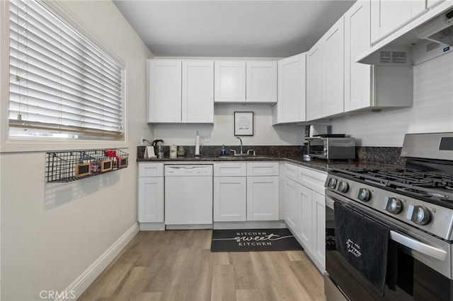 8626 Stark St, Riverside, CA 92504 - kitchen with stainless steel gas range oven, white dishwasher, under cabinet range hood, light wood-style floors, and white cabinetry