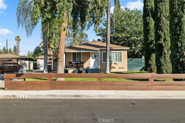 8626 Stark St, Riverside, CA 92504 - view of front of home with a fenced front yard, stucco siding, a porch, and a garage
