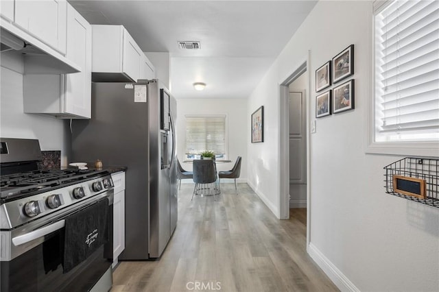 8626 Stark St, Riverside, CA 92504 - kitchen featuring stainless steel range with gas cooktop, ventilation hood, light wood-type flooring, and white cabinets