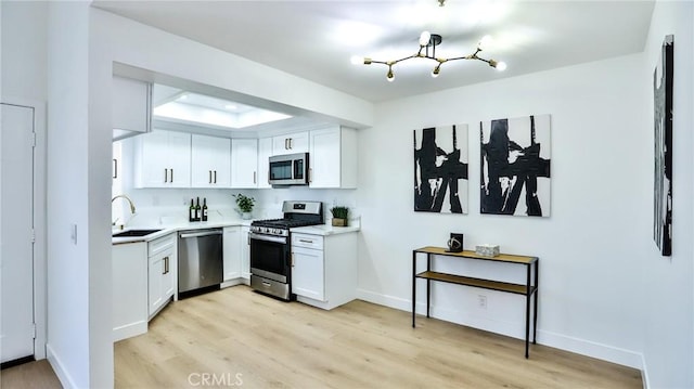 8810 Hewitt Pl Unit 2, Garden Grove, CA 92844 - kitchen featuring stainless steel appliances, light wood-style flooring, light countertops, and white cabinetry