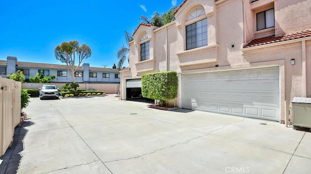 8810 Hewitt Pl Unit 2, Garden Grove, CA 92844 - view of front of home with a garage, a tile roof, and stucco siding