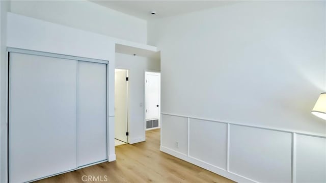 8810 Hewitt Pl Unit 2, Garden Grove, CA 92844 - unfurnished bedroom featuring wood finished floors, a closet, and wainscoting
