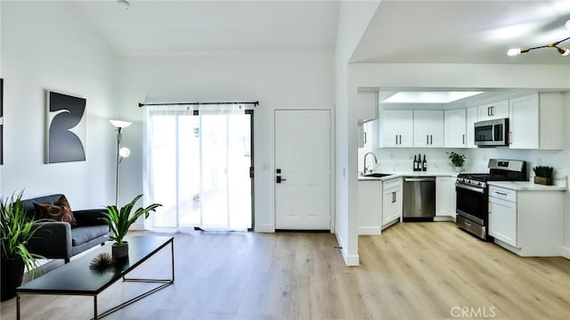 8810 Hewitt Pl Unit 2, Garden Grove, CA 92844 - kitchen featuring appliances with stainless steel finishes, white cabinetry, light wood-style floors, and light countertops