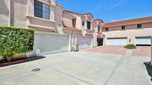 8810 Hewitt Pl Unit 2, Garden Grove, CA 92844 - view of property with stucco siding, a tiled roof, a garage, and driveway