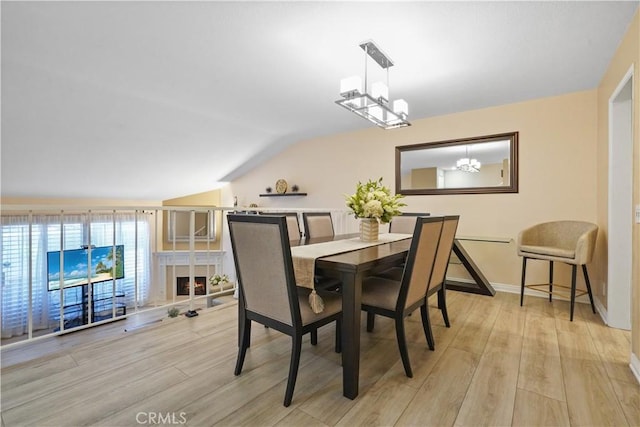 18230 Oxnard St Unit 110, Tarzana, CA 91356 - dining space featuring light wood-style flooring, lofted ceiling, and a chandelier