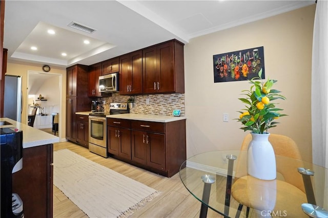 18230 Oxnard St Unit 110, Tarzana, CA 91356 - kitchen featuring appliances with stainless steel finishes, light countertops, decorative backsplash, light wood-style flooring, and recessed lighting