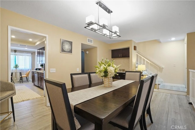 18230 Oxnard St Unit 110, Tarzana, CA 91356 - dining room featuring stairway, light wood-style flooring, recessed lighting, and a raised ceiling
