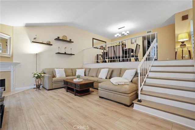 18230 Oxnard St Unit 110, Tarzana, CA 91356 - living room featuring stairway, wood finished floors, lofted ceiling, and a high end fireplace