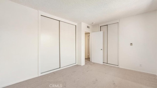 1115 Cordova St Unit 207, Pasadena, CA 91106 - unfurnished bedroom with a textured ceiling, multiple closets, and carpet flooring