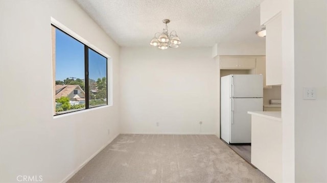 1115 Cordova St Unit 207, Pasadena, CA 91106 - unfurnished dining area with a chandelier, light colored carpet, and a textured ceiling