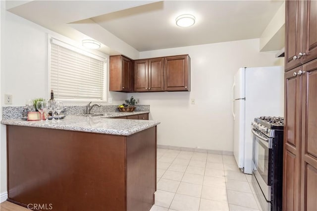 8825 Sophia Ave, North Hills, CA 91343 - kitchen featuring stainless steel gas stove, a peninsula, light stone countertops, and light tile patterned floors